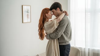 a man and woman embracing in a living room