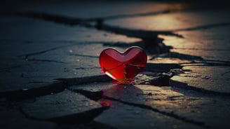 a broken heart shaped glass heart on a cracked - up floor