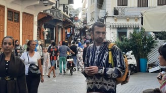 Tanger morocco a man walking down a street with people walking by