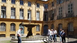 place avec une fontaine à Aix-en-Provence avec des personnes regardant l'architecture