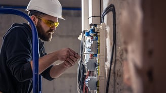 Tra technician installing HVAC ducts at a commercial project site