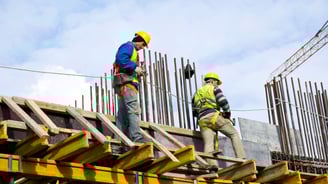 Tra team constructing a reinforced concrete building with scaffolding and structural beams on-sit