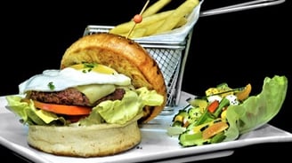 un burger avec une salade en accompagnement