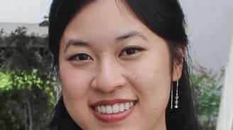 a woman with long black hair and earrings