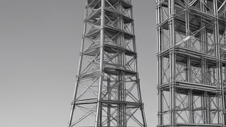 a couple of tall metal towers with a clock tower