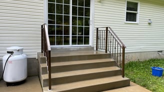 a house with a white door and stairs leading to a patio