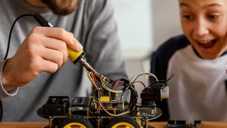 a man and a boy are building a robotic car