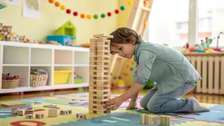 Un enfant joue avec des morceaux de bois kapla