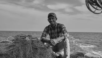 a man is sitting on a boat in the water