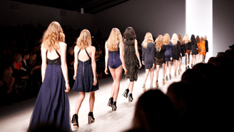 a group of models walking down a runway in fashion show