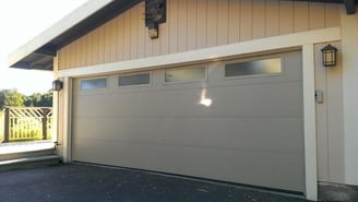 Flush panel steel garage door with glass.