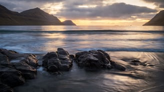 a sunset over a body of water in the Faroe Islands