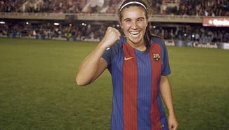 a woman in a soccer uniform is smiling and holding a cell phone