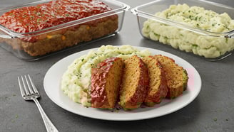 A hearty slice of turkey meatloaf served with creamy cauliflower mash, a nutritious and low-carb meal.