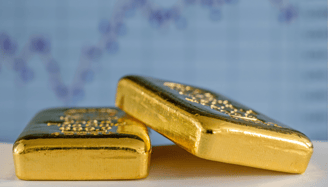 gold bullion bars on a flat surface with chart in the background