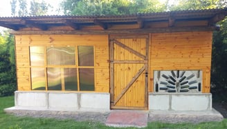 a small wooden cabin with a door and a window