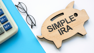 piggy bank a calculator and glasses for a simple ira