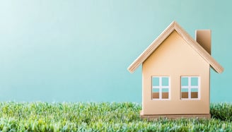 mini house on grass for symbolizing real estate ira investing