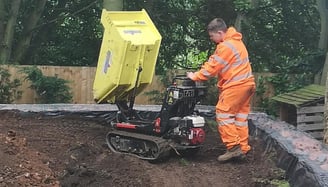 micro digger being pushed by a cmr grab and digger hire employee