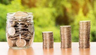 coins in a jar and in stacks consecutively growing larger