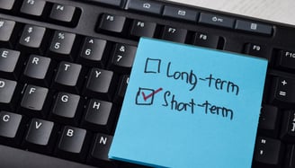 post it note with short term box checked and a keyboard