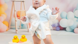 a baby in a white robe and a rubber ducky ducky