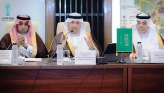 a group of men sitting at a table with microphones