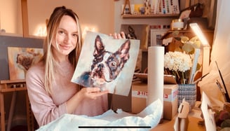 Alex Goddard holding one of the prints she made through the print on demand company Gelato.