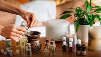 a person is holding a bottle of essential oils