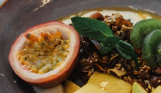 alt="Bol de yaourt gourmand garni de fruits frais , granola maison"