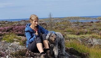 The Dog-Walker sitting on a rock in the moorland, comforting a grey fluffy Dog