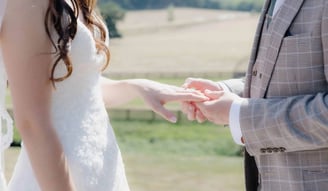 Groom placing a ring onto the finger of the bride