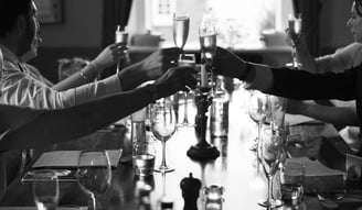 Classy black and white photo of wedding guests drinking champagne