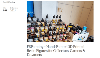 Set of acrylic paints and airbrush tools used for hand-painting resin figures in a studio setting