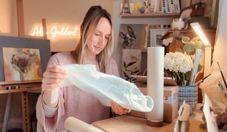 Alex working in her studio wrapping print order for shipping