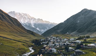a small town in the mountains with a mountain in the background