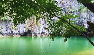 Vista da entrada da caverna com águas claras refletindo a luz.