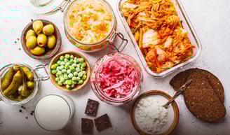 a table with a variety of fermented foods and probiotics in glass containers