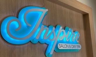 Inspire Salon and Day Spa logo sign displayed above the reception desk is stylish and relaxing.