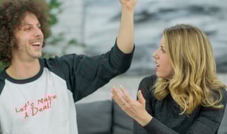 a man and woman are holding hands up in the air