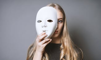 Syndrome de l'imposteur - Femme blonde qui met un masque devant son visage pour le cacher