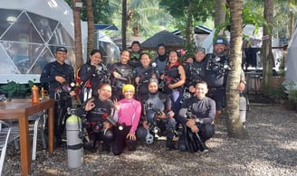 group of scuba divers, happily posing going into the dive in Dauin, Negros, the muck diving capital 