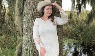 a woman in a white dress and cowboy boots
