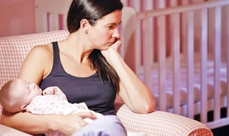 a woman sitting in a chair with a baby