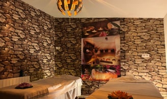 a couple of beds in a room with stone walls
