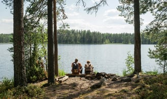 a couple sitting on a bench in the woods