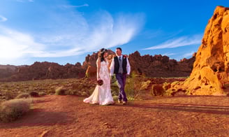 a man and woman standing in front of red rocks at Valley of Fire State Park