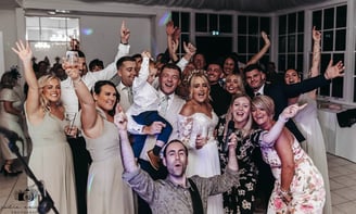 bride and group having fun with wedding singers and band