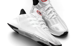 a pair of white sneakers with a red and black shoelace