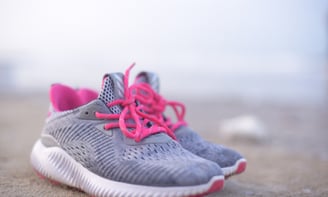 a pair of sneakers with pink laces on them